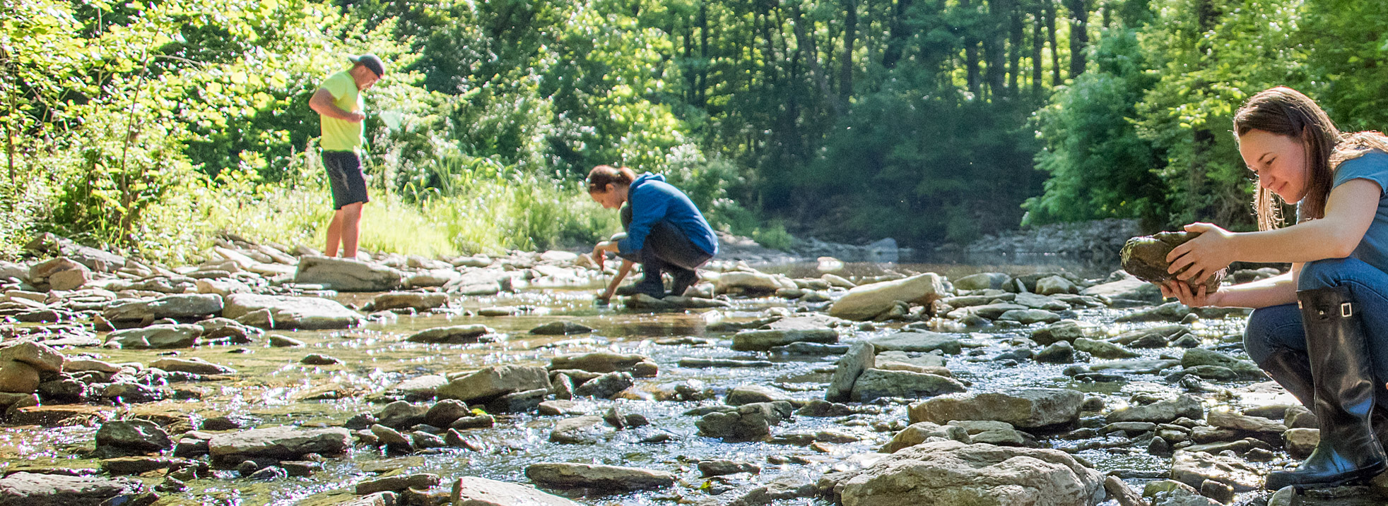 WaterQualityRename Three educators exploring creek and observing rocks